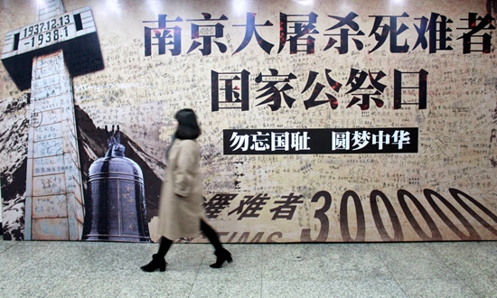 2016年12月12日,南京,市民从地铁站的"国家公祭日和平许愿墙"边经过.